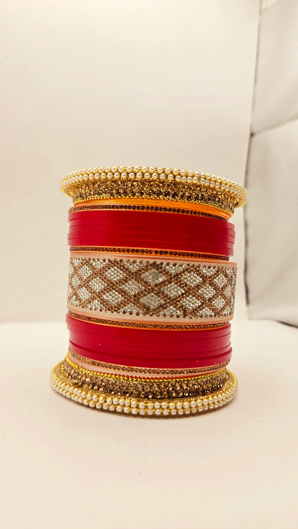 Set of red and gold bangles on a light background